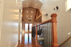 vaulted hallway next to a wood and cast iron railing