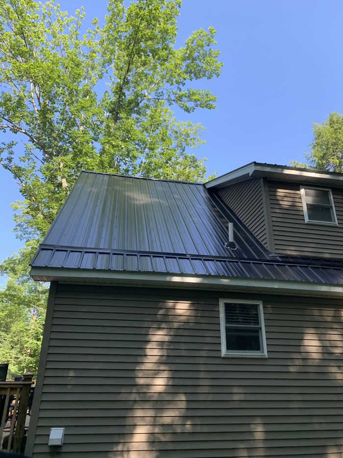 home with vinyl siding and new metal roof