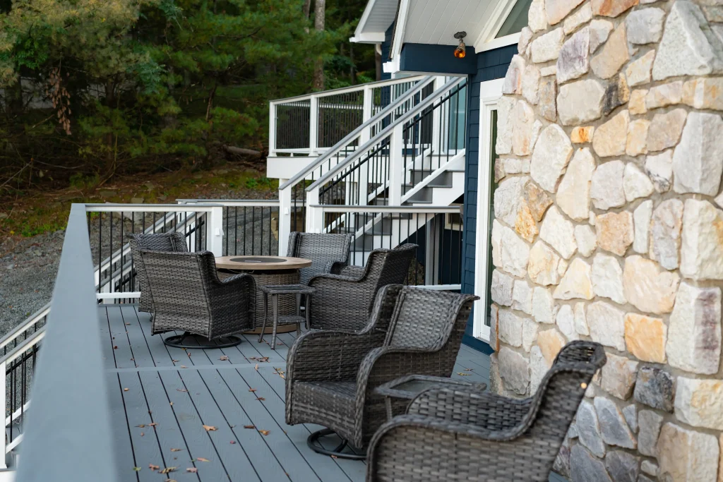 Original patio seating area and old deck layout next to a stone chimney before a custom Trex deck and TexDeck remodel by NEPA builders.