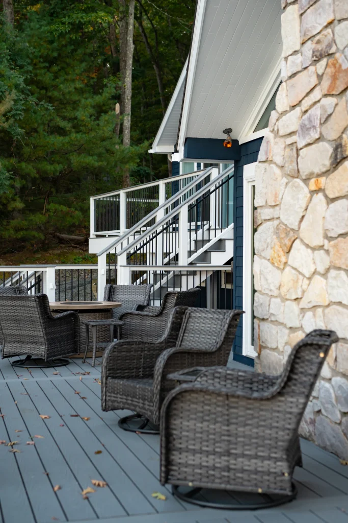 Original lower patio seating area next to a stone chimney before a custom Trex deck and TexDeck remodel by NEPA builders.