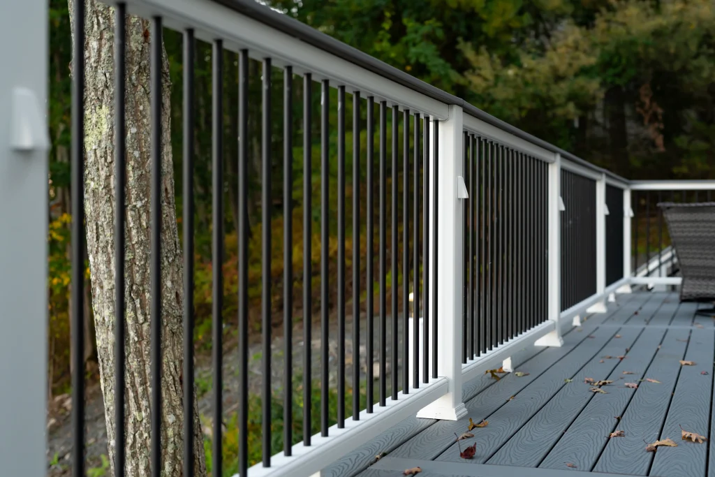 Close-up of gray composite Trex deck boards and a white TexDeck railing system with black balusters, installed by NEPA builders in Pennsylvania.