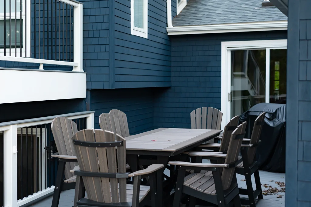 Outdoor patio dining set on a custom Trex deck with TexDeck materials, featuring a blue house exterior, installed by NEPA builders in Pennsylvania.