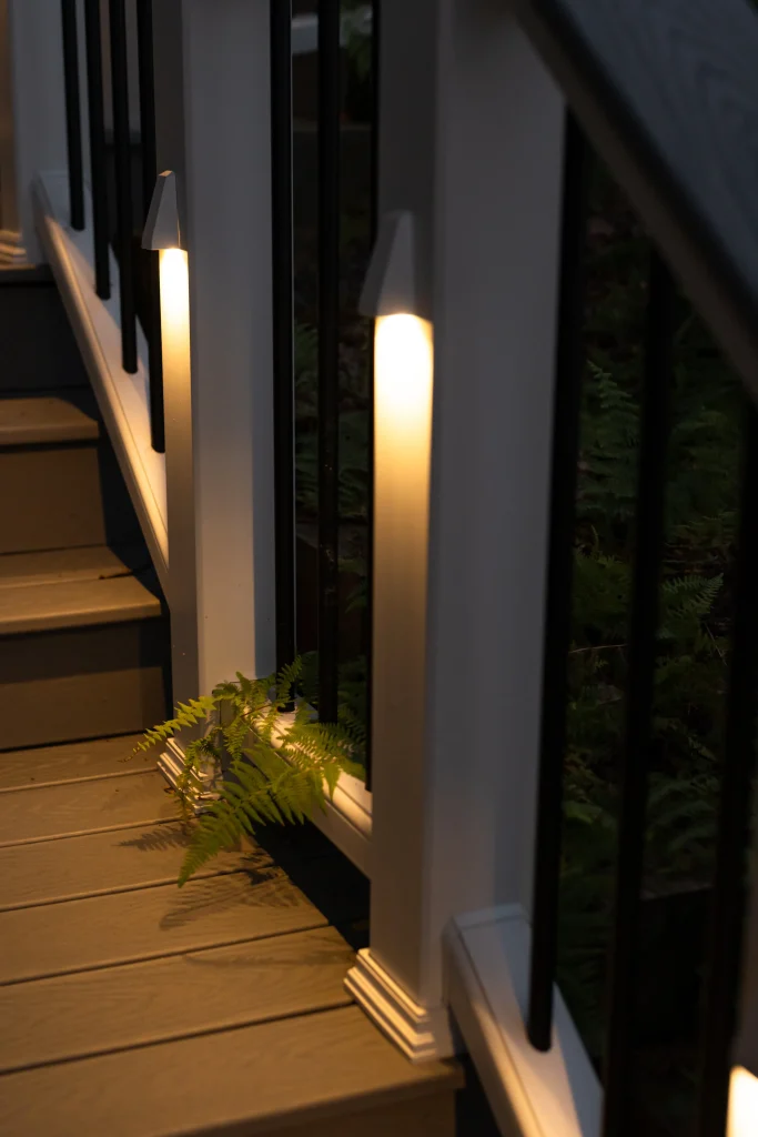 Close-up of glowing TexDeck LED post lights illuminating the steps of a newly completed custom Trex deck, installed by NEPA builders.
