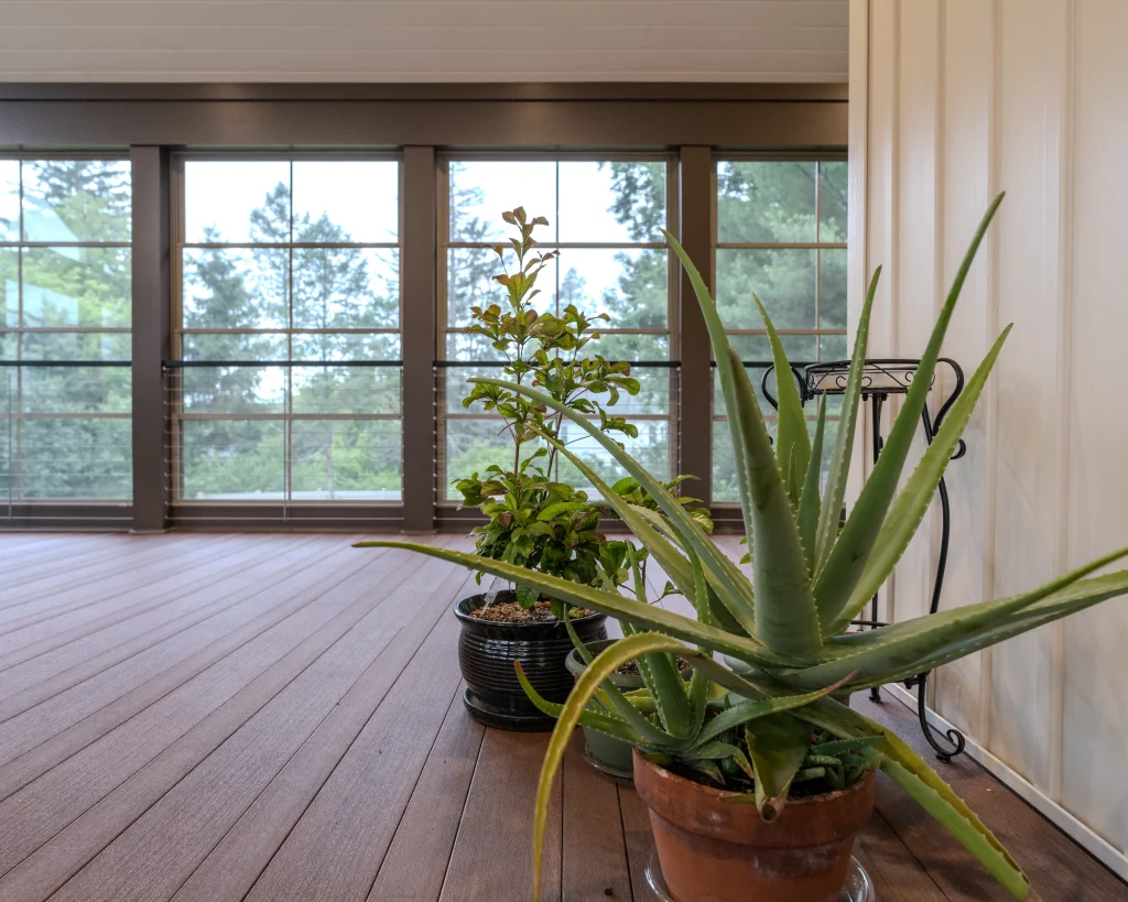 Spacious three-season outdoor living room in Dalton, PA featuring TimberTech PVC porch decking, Eze-Breeze windows, and abundant natural light by NEPA Builders.