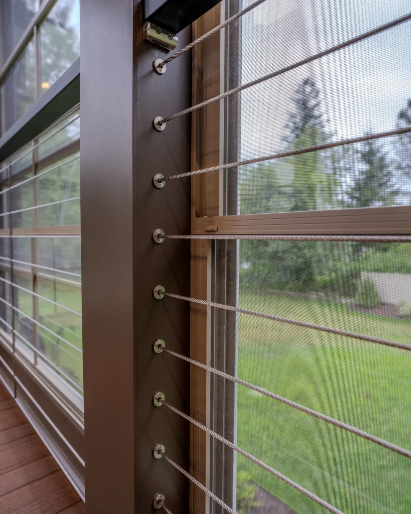 Close-up of the Eze-Breeze window system and cable railing inside a custom three-season outdoor living space in Dalton, PA built by NEPA Builders.