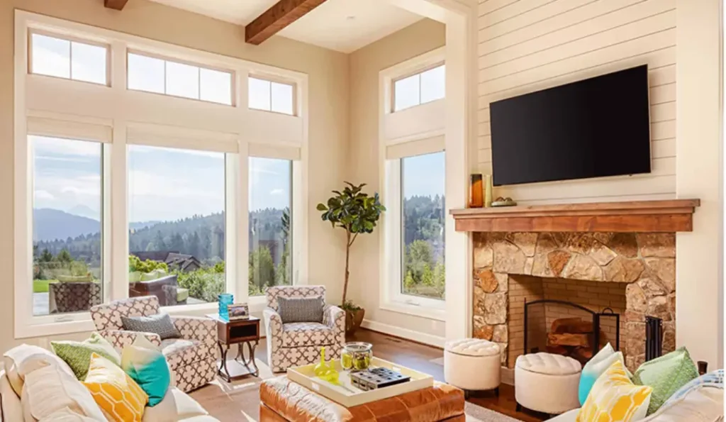 Interior windows overlooking a beautifully hilly countryside from a quaint sitting room with fireplace.
